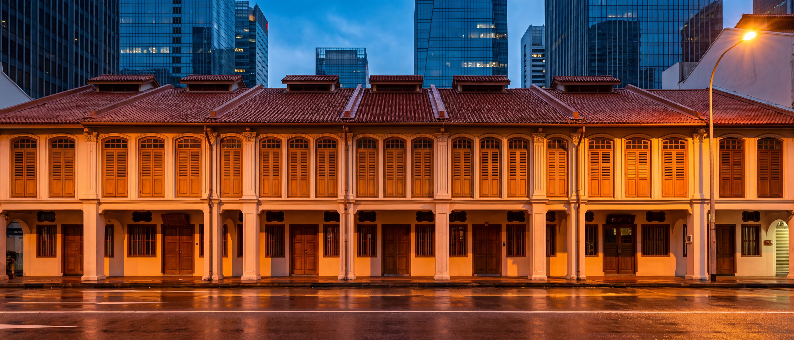Shophouses along Telok Ayer at dusk, lit from within